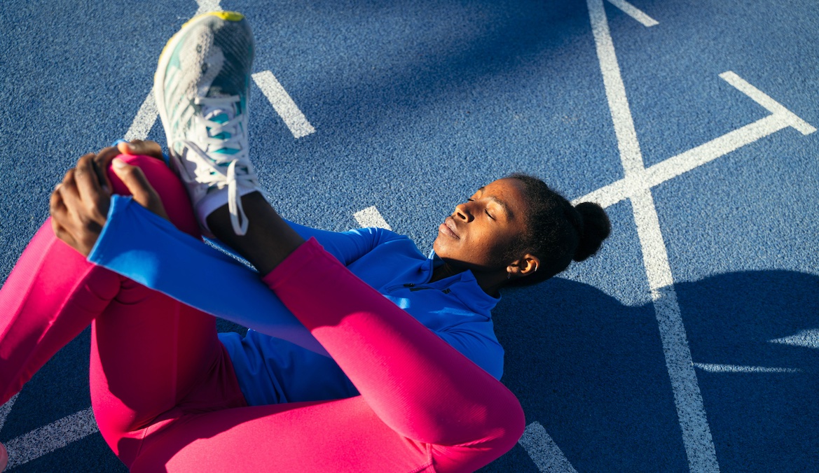 photo of a woman stretching for a run with sneakers on