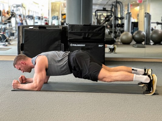 Personal trainer demonstrating forearm plank