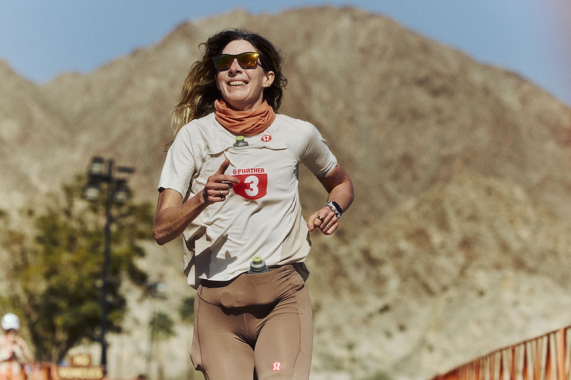 an image of Camille Herron, an ultrarunner in perimenopause, running with a desert mountainous background at the lululemon further event