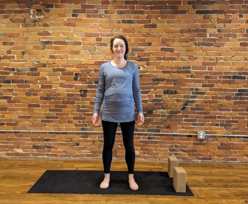Schwangere Person macht Bergpose-Yoga