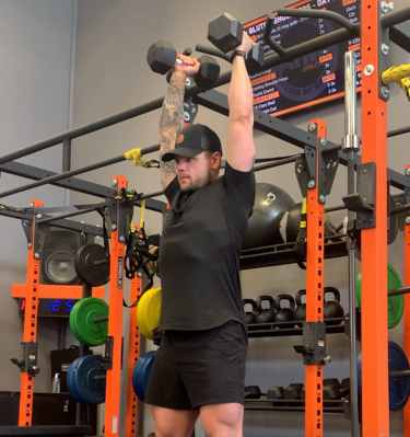 Personal trainer demonstrating overhead press
