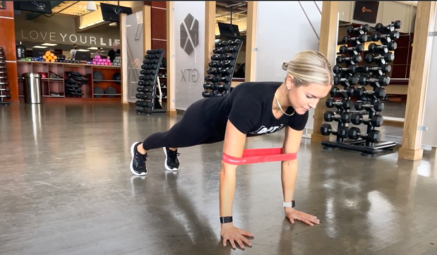 Personal trainer demonstrating push-up modification using mini band
