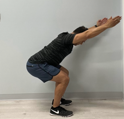 Personal trainer demonstrating a squat
